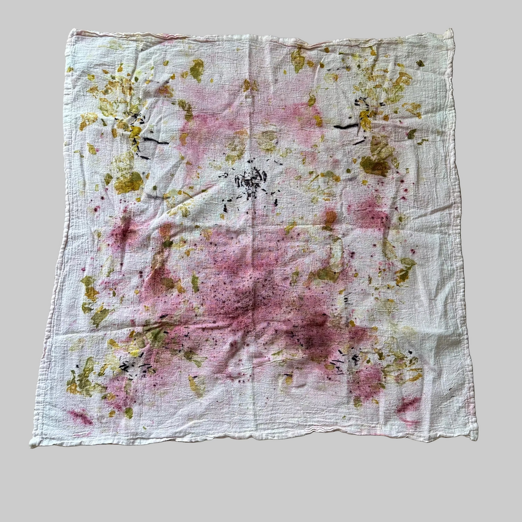 White flour sack dish towel with pink (cochineal) and yellow/green  (onion skins) and log wood (purple) floral pattern.