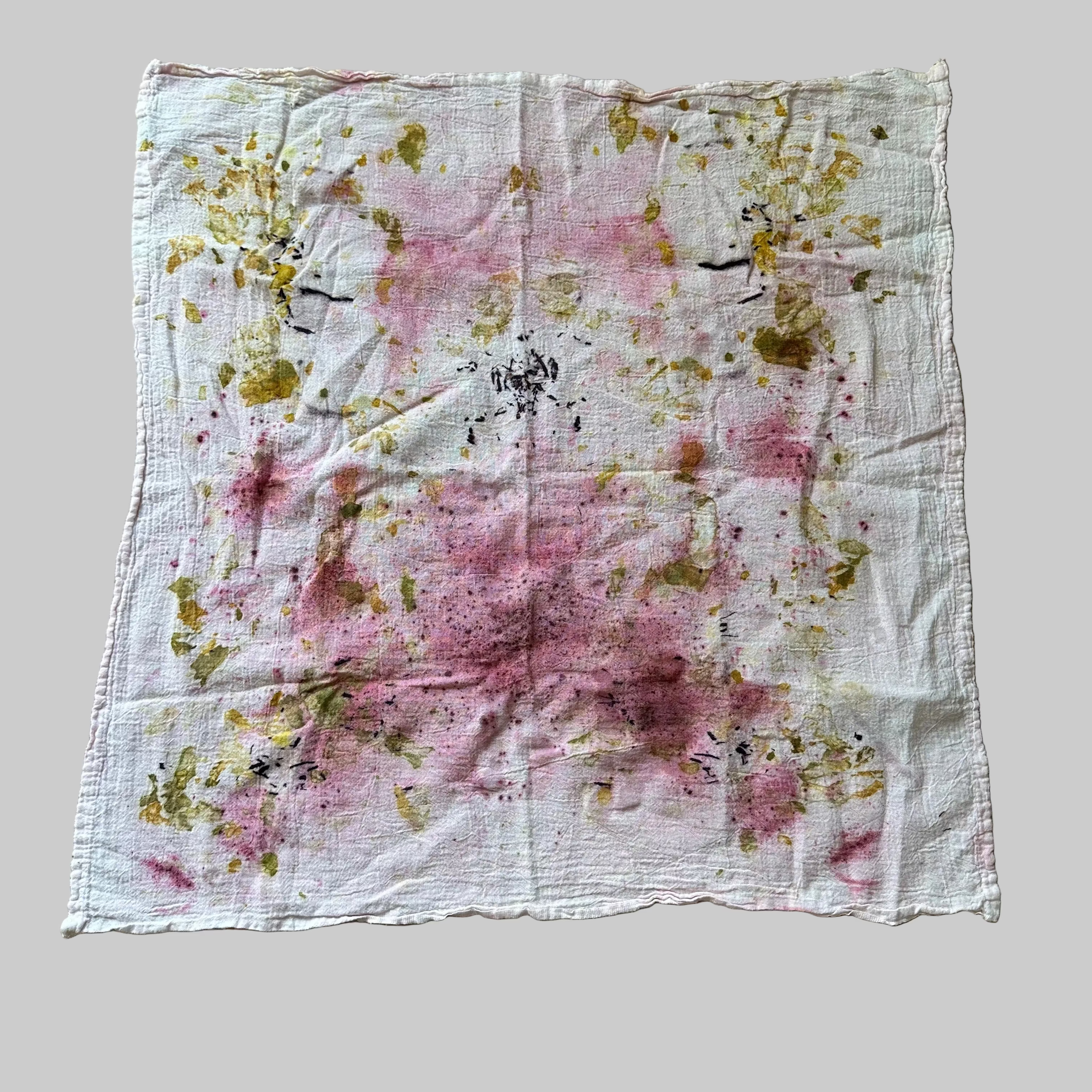 White flour sack dish towel with pink (cochineal) and yellow/green  (onion skins) and log wood (purple) floral pattern.